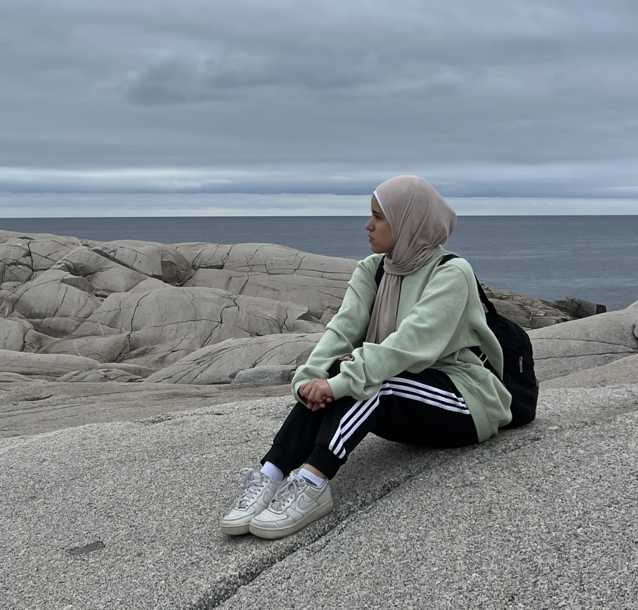 image of Amina sitting on rocks